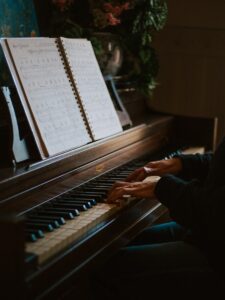 man playing the piano in front of open music book